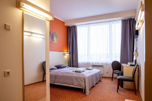 a hotel room with a bed and a mirror at Rija Bauska Hotel in Bauska