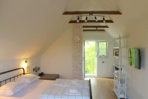 een slaapkamer met 2 bedden en een bakstenen muur bij House with hot tub, sauna and swimming pool near Zagreb in Gudci