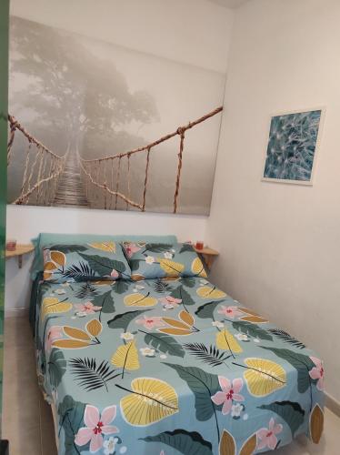 a bedroom with a bed with a blue comforter with flowers at Playa Celeste Tajao in La Mareta