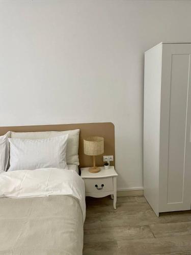 une chambre avec un lit et une table avec une lampe dans l'établissement Cozy Appartement Halles Strasbourg, à Strasbourg