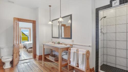 een badkamer met een wastafel, een toilet en een spiegel bij Sail Inn Lunenburg in Lunenburg