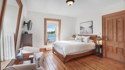 1 dormitorio con cama y ventana en Sail Inn Lunenburg, en Lunenburg