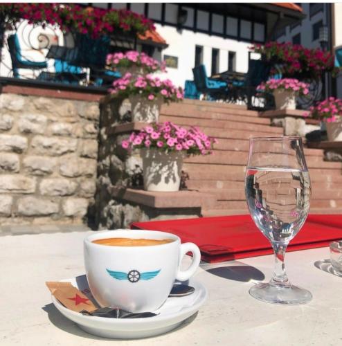 a cup of coffee and a wine glass on a table at Apartman "MiLa" - Titova vila Zlatibor in Zlatibor