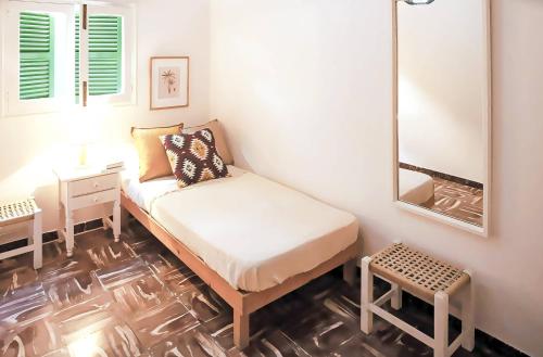 Dormitorio pequeño con cama y espejo en Apartamento Ses Botges - Formentera Break, en Es Caló