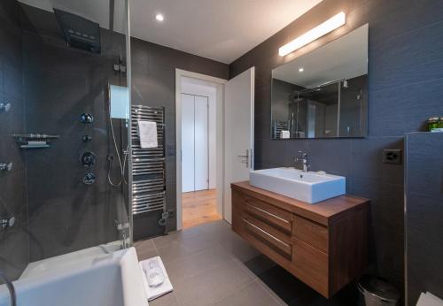 a bathroom with a sink and a shower at Chalet Stella Alpina in Wengen