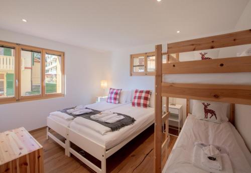 a bedroom with two bunk beds and a desk at Chalet Stella Alpina in Wengen