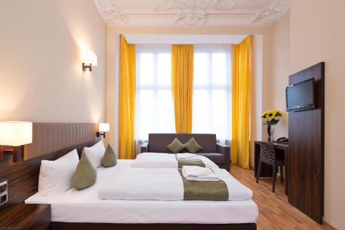 ein Hotelzimmer mit einem großen Bett und einem TV in der Unterkunft Hotel Abendstern in Berlin
