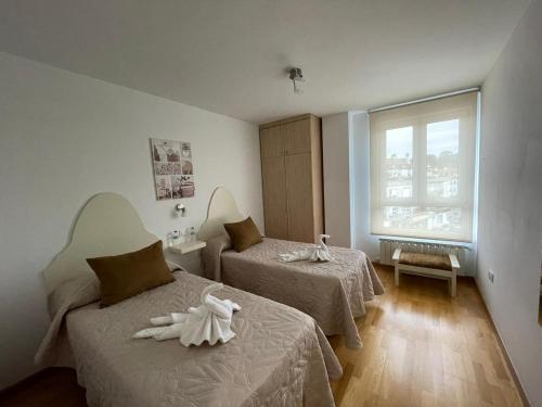 um quarto de hotel com duas camas e uma janela em Saron Centro 1 em Sarón