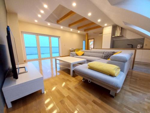 uma sala de estar com um sofá e uma televisão em Apartament Lusowo em Lusowo
