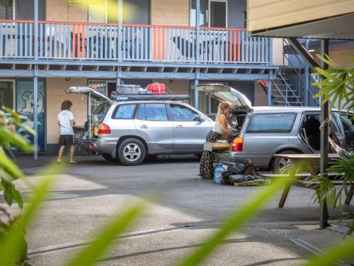 een paar auto's geparkeerd op een parkeerplaats bij Castaways Backpackers Cairns in Cairns