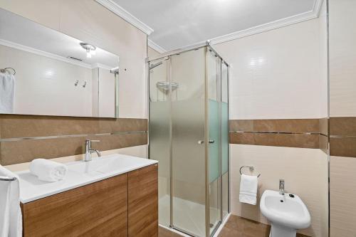 a bathroom with a sink and a glass shower at El rincón de Rosa in Granada