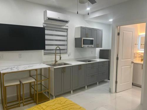 a kitchen with a sink and a stove top oven at Stunning Deluxe Studio in Hialeah