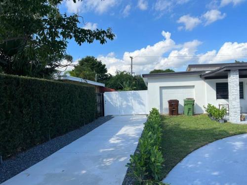 a driveway in front of a white house at Stunning Deluxe Studio in Hialeah