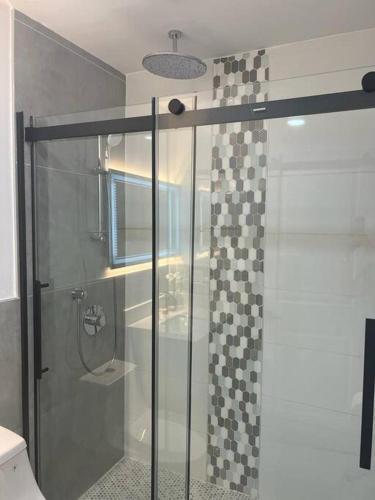 a shower with a glass door in a bathroom at Stunning Deluxe Studio in Hialeah