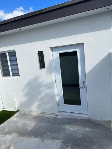 a white building with a door on the side of it at Stunning Deluxe Studio in Hialeah