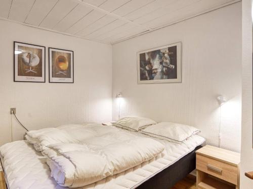 a bed in a room with pictures on the wall at 6 person holiday home in Dannemare in Nakskov