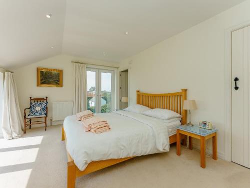 a white bedroom with a bed and a table at Bron Gors in Ederyn