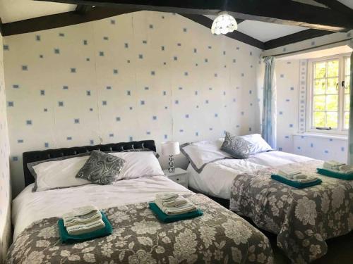 a bedroom with two beds with towels on them at Spacious Countryside/Suburban Retreat-Warwickshire in Walsgrave on Sowe
