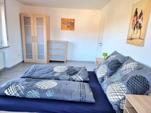 Un dormitorio con una cama azul con almohadas. en Schöne Wohnung auf der Schwäbischen Alb en Münsingen