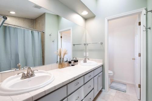 a bathroom with two sinks and a shower at The Place To Be; With A Hot Tub! in Clackamas