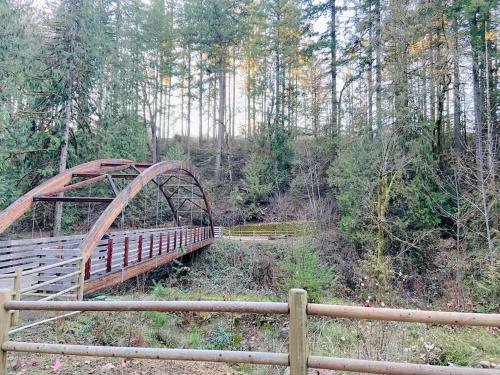 a wooden bridge in the middle of a forest at The Place To Be; With A Hot Tub! in Clackamas