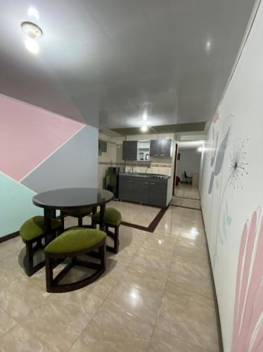 Acogedor y céntrico aparta estudio cerca del aeropuerto في بوغوتا: غرفة مع طاولة وكراسي ومطبخ