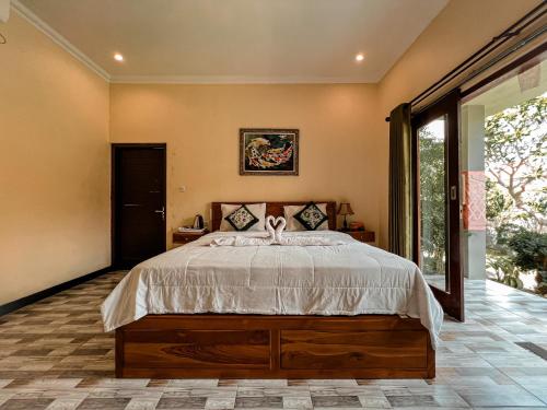 1 dormitorio con cama y ventana grande en Gayatri Bungalows, en Nusa Penida