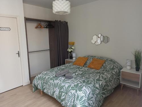 - une chambre avec un lit et une couette verte et blanche dans l'établissement Faubourg de la Cueille - Aux portes du Futuroscope, à Poitiers