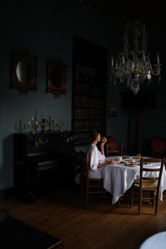 a woman sitting at a table in a dining room at Hotel Emblemático La Casa de los Naranjos in Haría