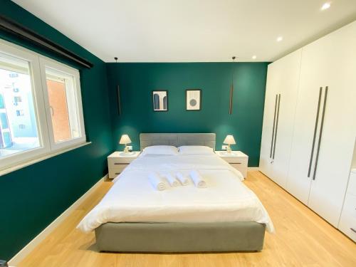 a bedroom with a large bed with green walls at Matisse No9 - One Bedroom City Center Apartment With Parking in Tirana