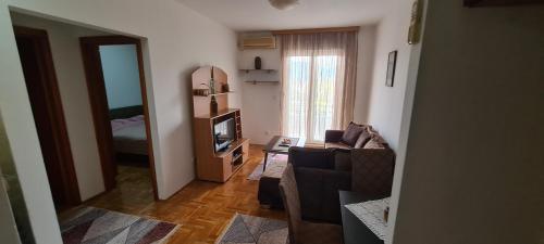 een woonkamer met een bank en een televisie bij Apartman Velimir Stari Aerodrom in Svijetin Brijeg