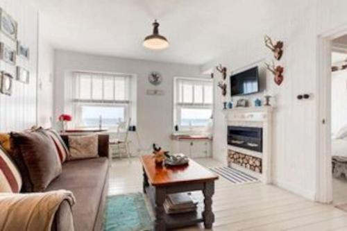a living room with a couch and a table at Stunning sea view apartment in St. Leonards