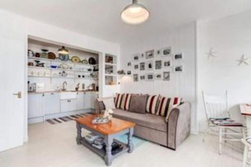 a living room with a couch and a table at Stunning sea view apartment in St. Leonards