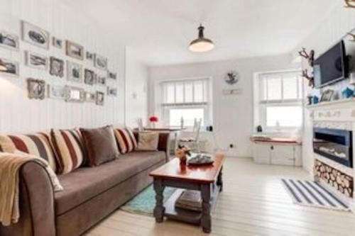 a living room with a couch and a coffee table at Stunning sea view apartment in St. Leonards