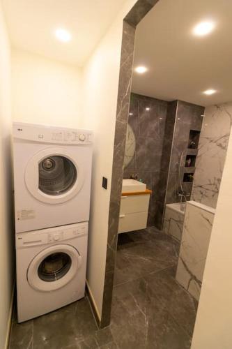 une machine à laver dans une salle de bain avec douche dans l'établissement Parking Gratuit - Chic et Elégant à Villeurbanne - Tout Fourni, à Villeurbanne