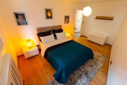 ヴィルールバンヌにあるChic et Elégant à Villeurbanneのベッドルーム1室(大型ベッド1台、青い毛布付)