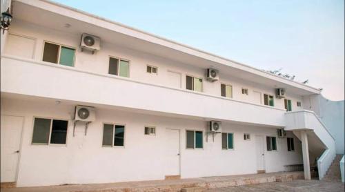 a large white building with green windows at VILLAS MARQUIS in Ciudad Valles