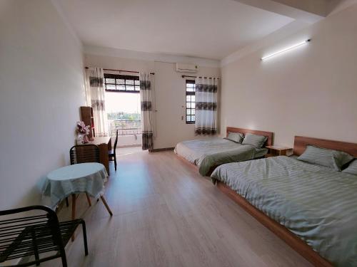 Zimmer mit 2 Betten, einem Tisch und einem sidx sidx sidx in der Unterkunft Nhà nghỉ Bonne Vie' Homestay in Cần Thơ