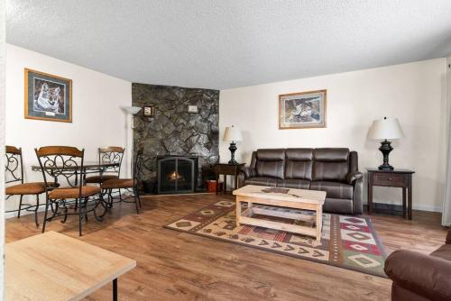 a living room with a couch and a table and a fireplace at Alaskan WolfDen Close to airport centrally located in Anchorage