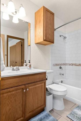 a bathroom with a sink toilet and a mirror at Alaskan WolfDen Close to airport centrally located in Anchorage