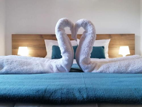two swansrendered to look like they are kissing on a bed at A Casa da Formosinha in Madalena