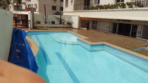 a large blue swimming pool in a building at Apto com conforto que você precisa. in Goiânia