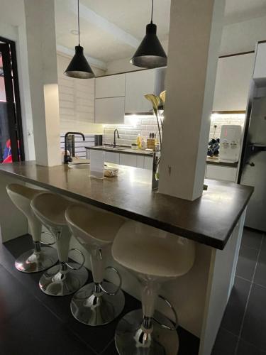 a kitchen with a large counter with stools under it at sukebumie7 in Shah Alam