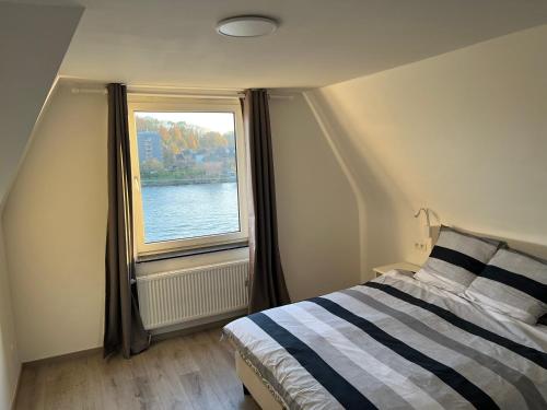a bedroom with a bed and a window at Riverbank Guest House in Namur