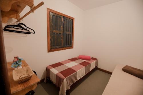 Habitación pequeña con cama y ventana en Apartamentos Prana, en Itacaré