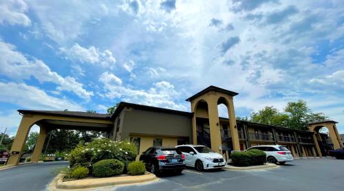 a building with two cars parked in a parking lot at Luxury Inn & Suites in Selma