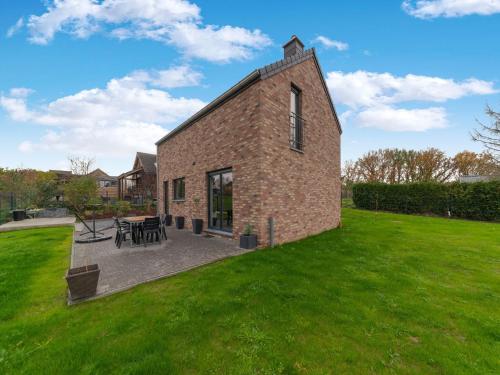 a brick building with a patio in a yard at Holiday home in Noiseux with fenced garden in Noiseux