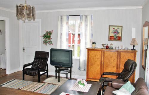 - un salon avec une télévision et deux chaises dans l'établissement 2 Bedroom Gorgeous Home In Tving, à Tving