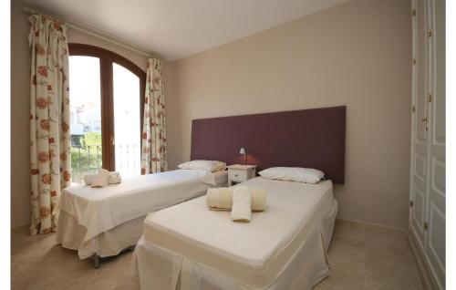 two beds in a room with a window at Amazing Home In Benahavs With Swimming Pool in Estepona