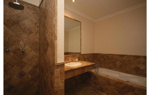 uma casa de banho com um lavatório, um espelho e uma banheira em Amazing Home In Benahavs With Swimming Pool em Estepona